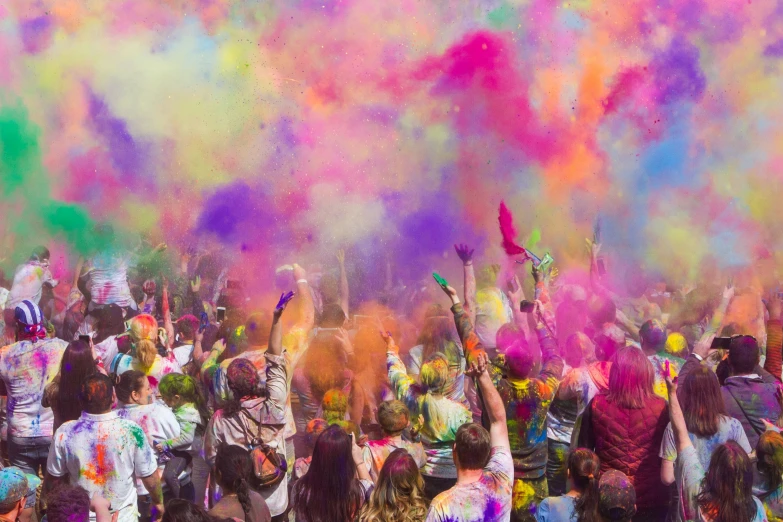 crowd of people at a festival throwing colors