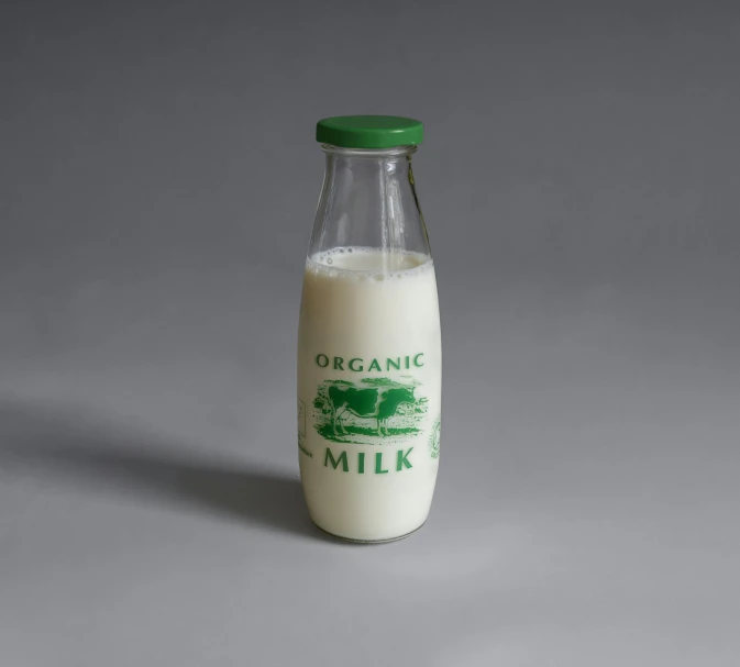 organic milk in a glass bottle on gray background