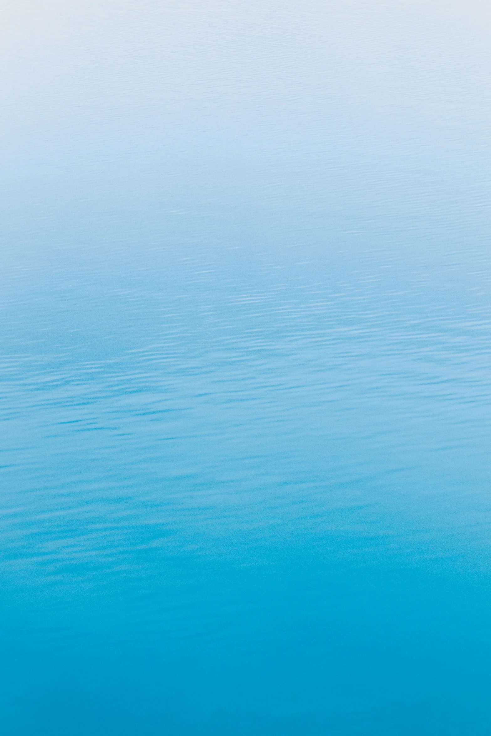 a blue sky with water waves and a boat floating in it