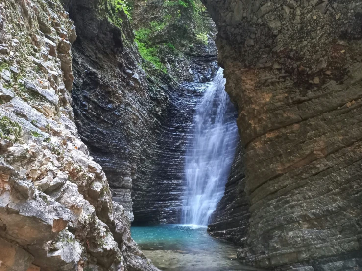 a small waterfall at the bottom of an canyon