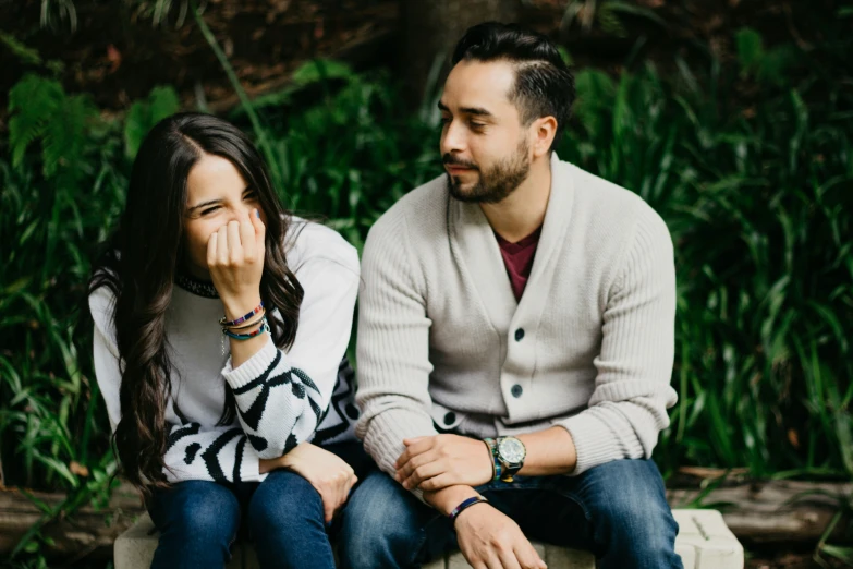 a man and woman sitting down next to each other