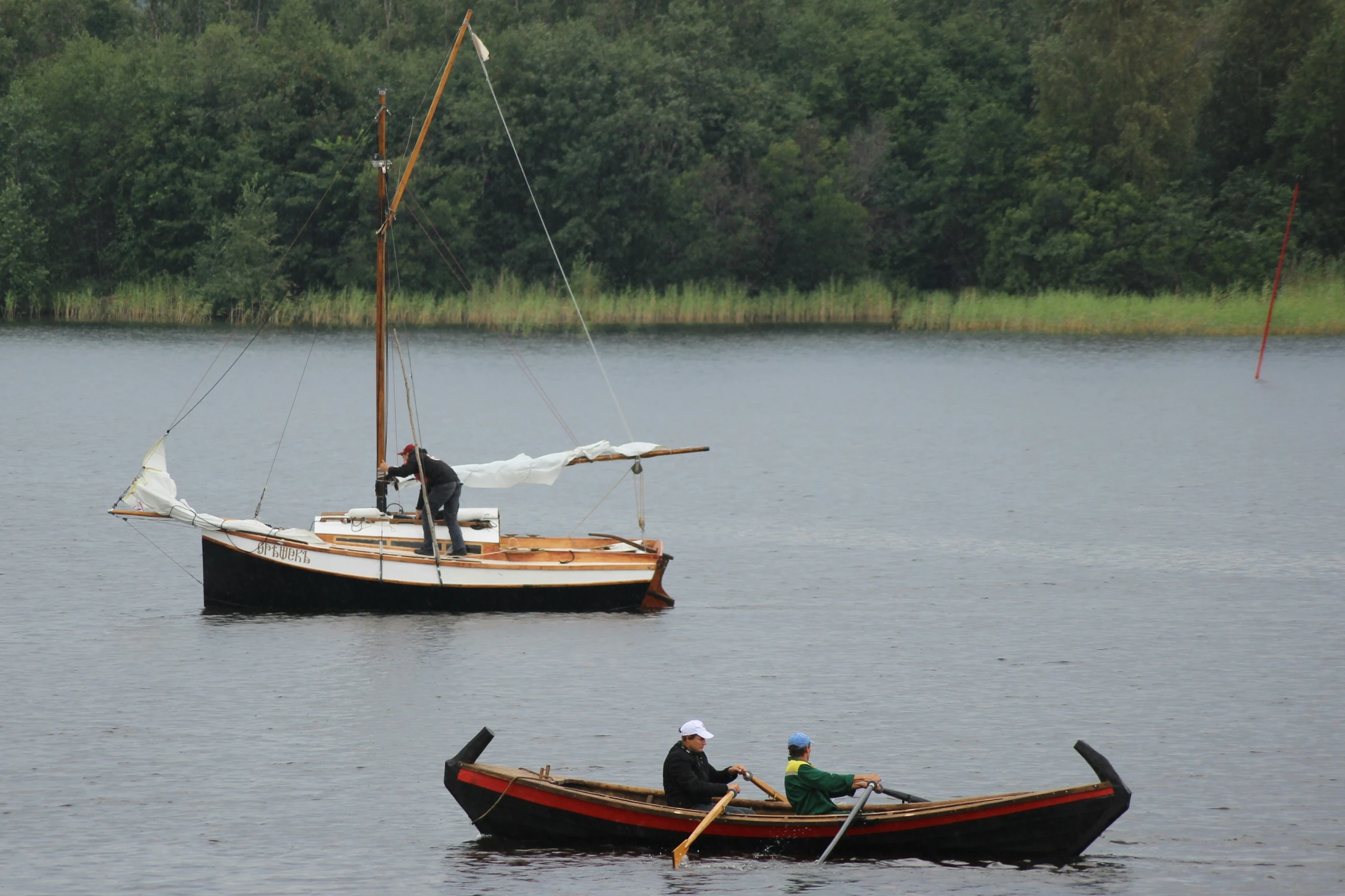 three boats in the water with people in them