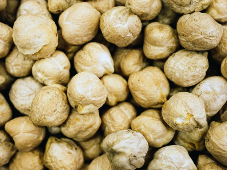 closeup image of whole and unpeeled peanuts