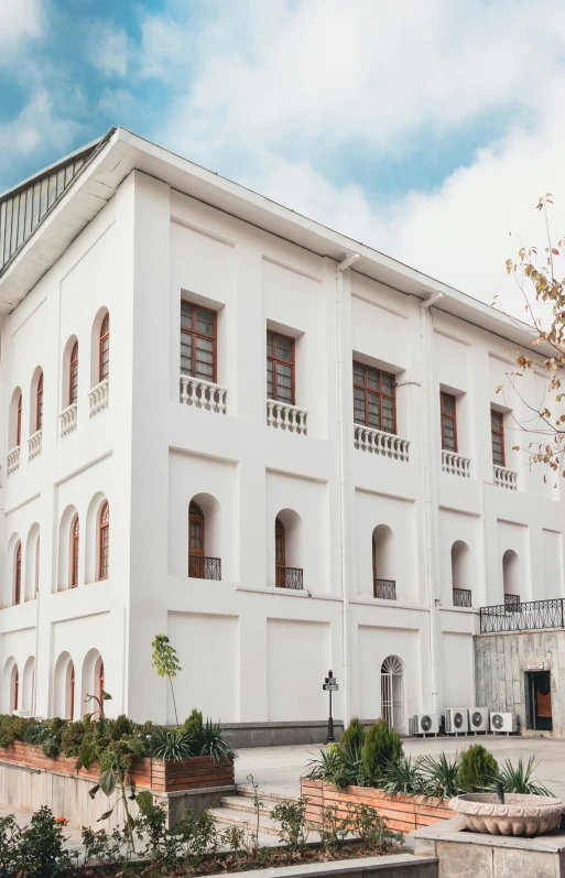 the large white building has many windows and balconies