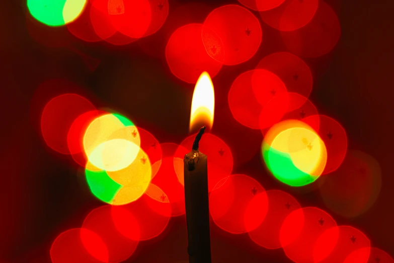 a candle sitting in front of colorful lights