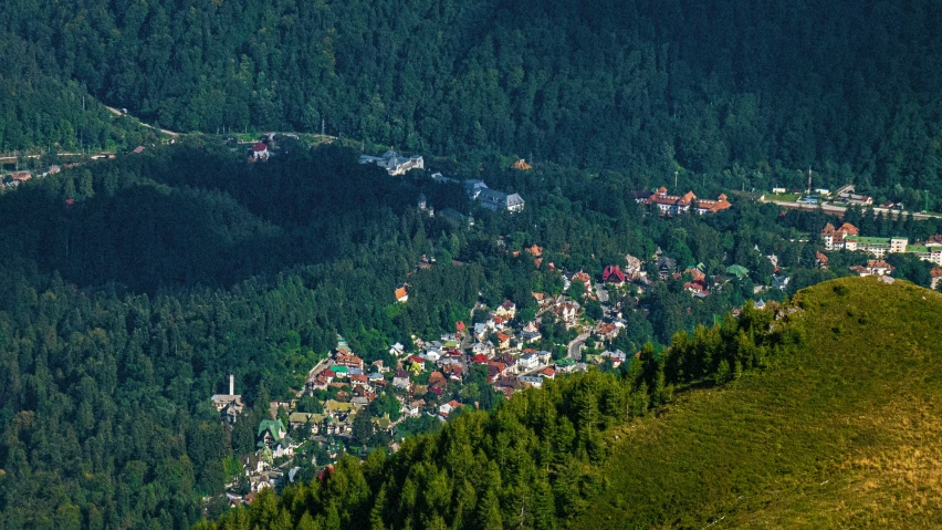 an aerial view of a town in the middle of some green hills
