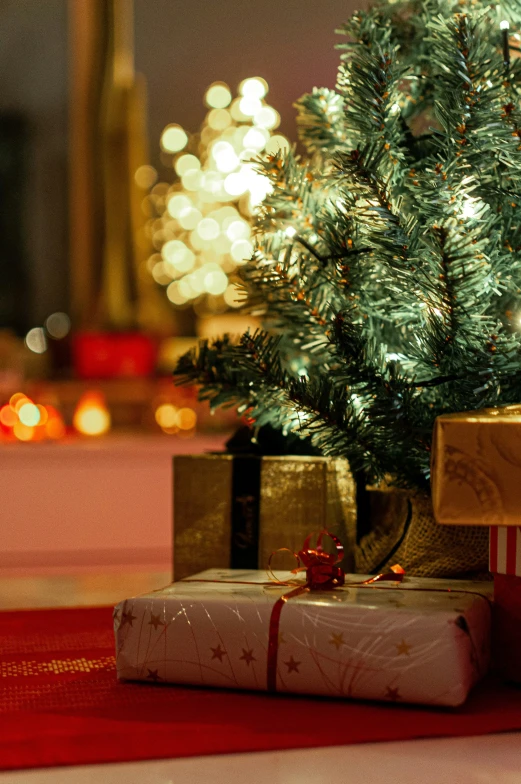 present boxes sitting under a small christmas tree