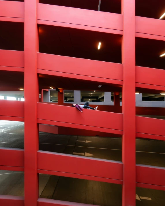 the inside of an open parking garage with a car parked on one side and a parking lot off to the side