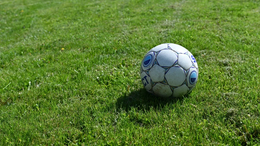 there is an old soccer ball on the grass