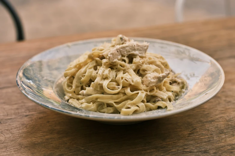 bowl of food with noodle on wooden table