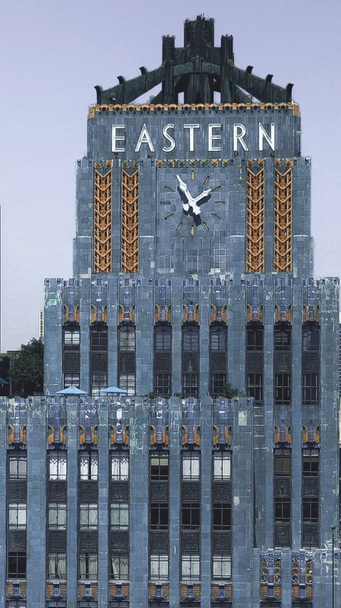 a clock on the side of a building with a tower behind it