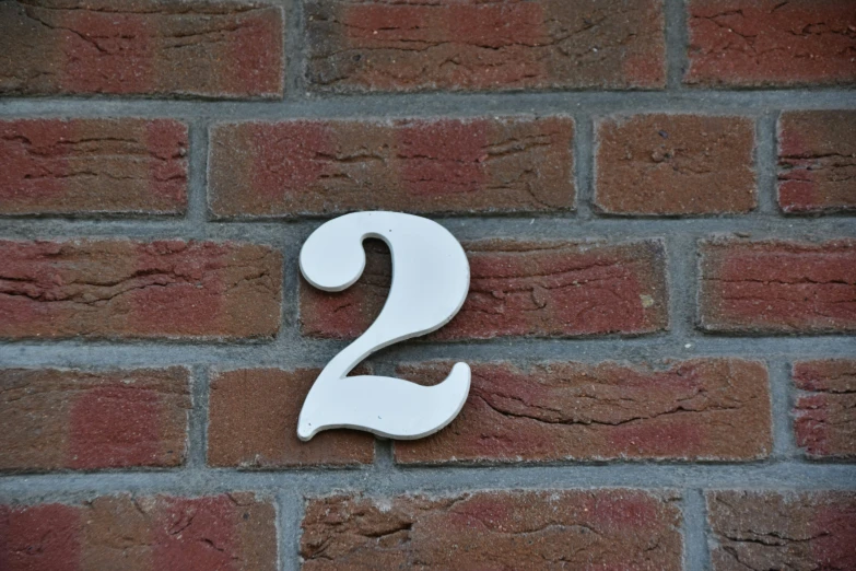 a close up of the number 2 on a brick wall