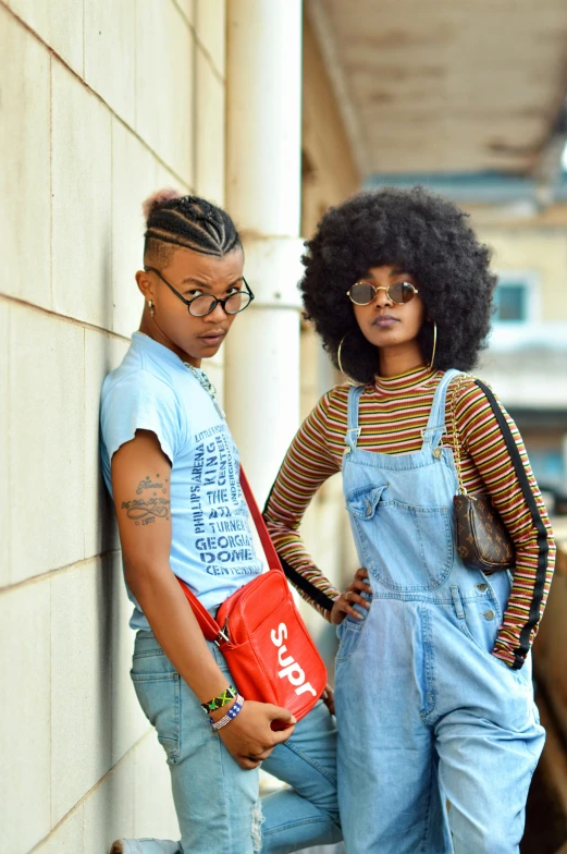 the african american couple is standing outside wearing overalls