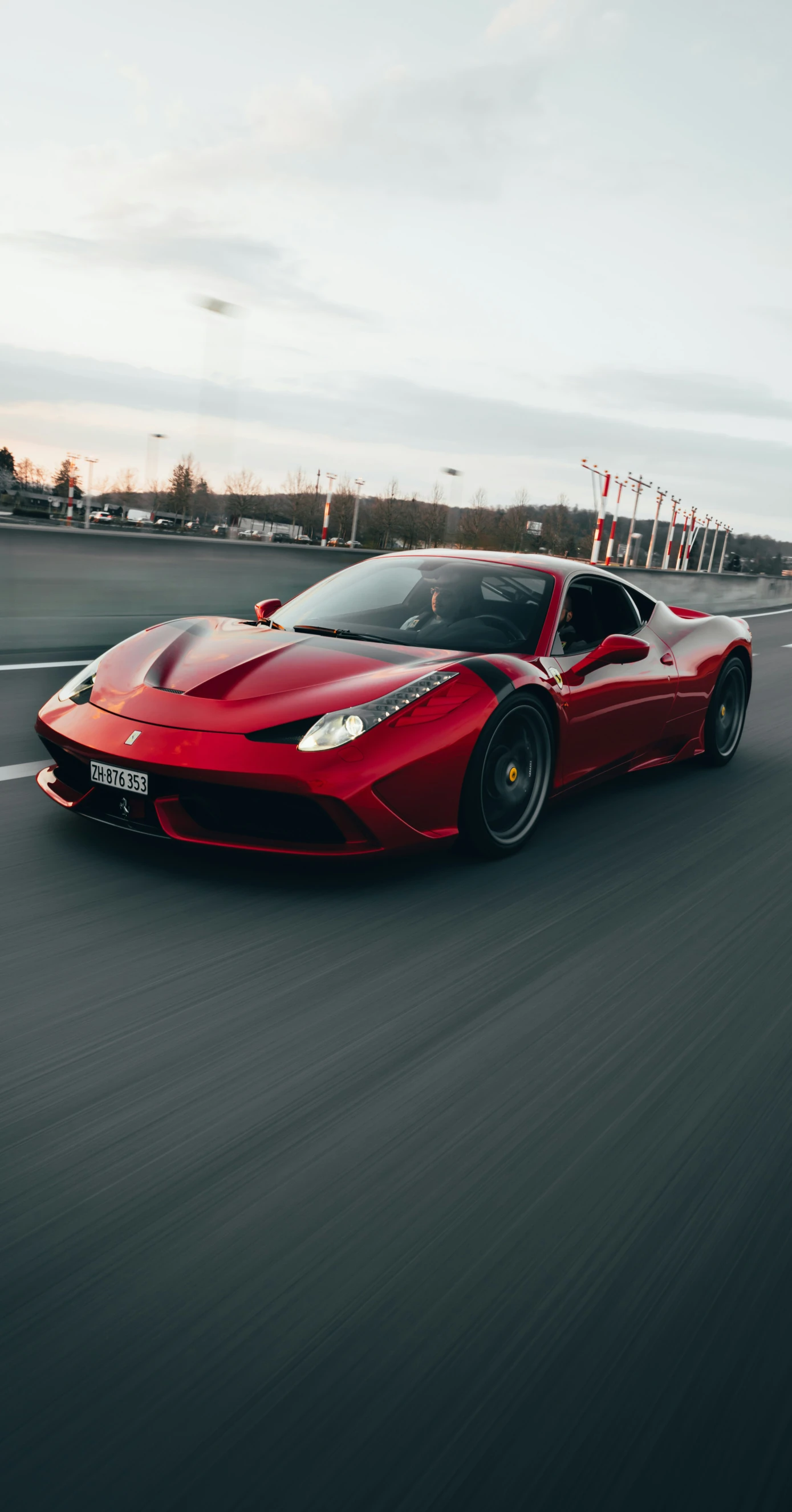 a red sports car speeds down the road