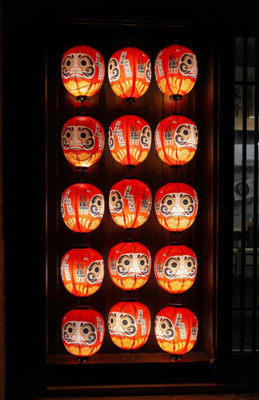 lighted lanterns displayed in front of metal bars with skeleton faces and skulls