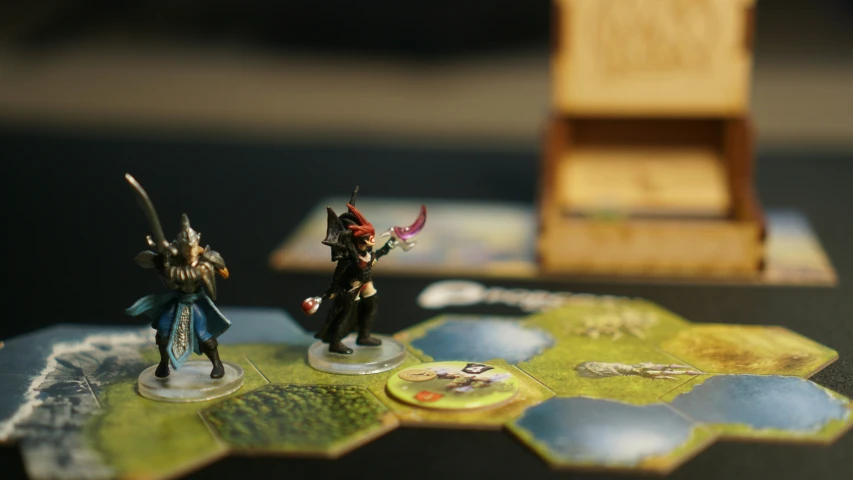 a pair of figurines on a board game with a wooden board in the background