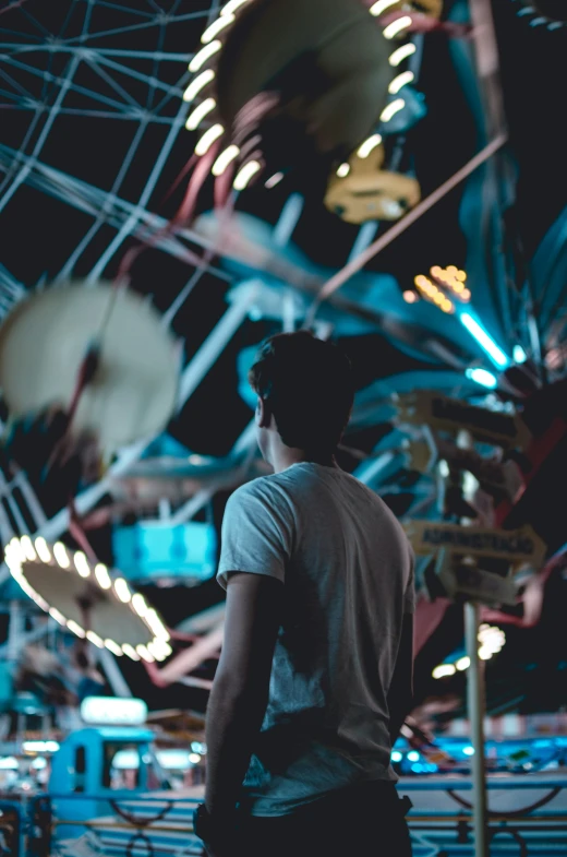 a person standing in front of an illuminated carousel