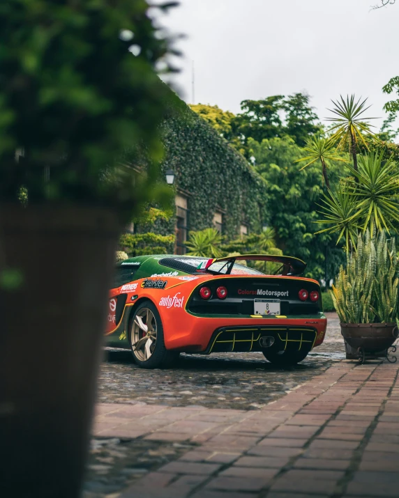 a red sports car in front of some trees and shrubbery