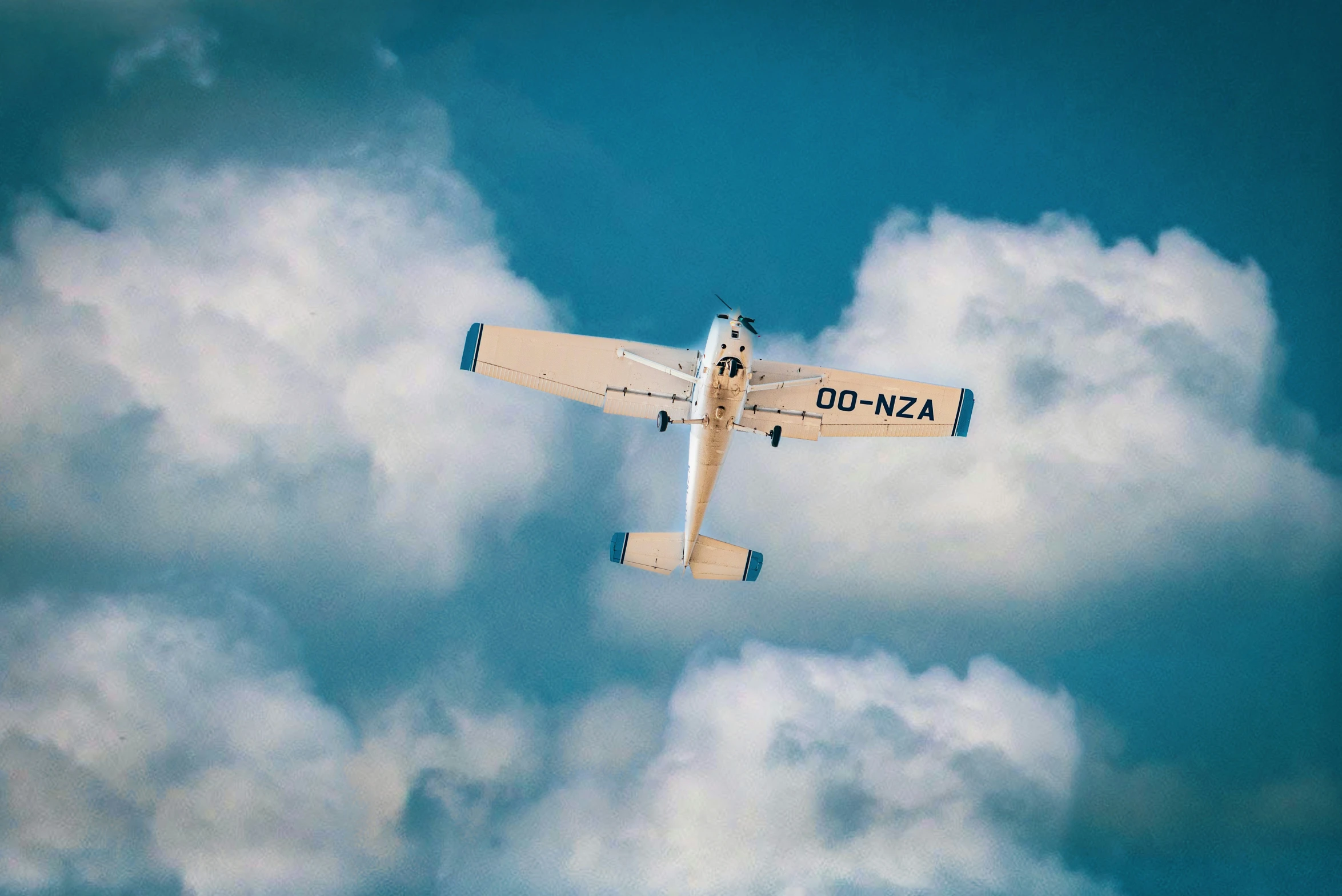 a plane flies in the sky above fluffy clouds