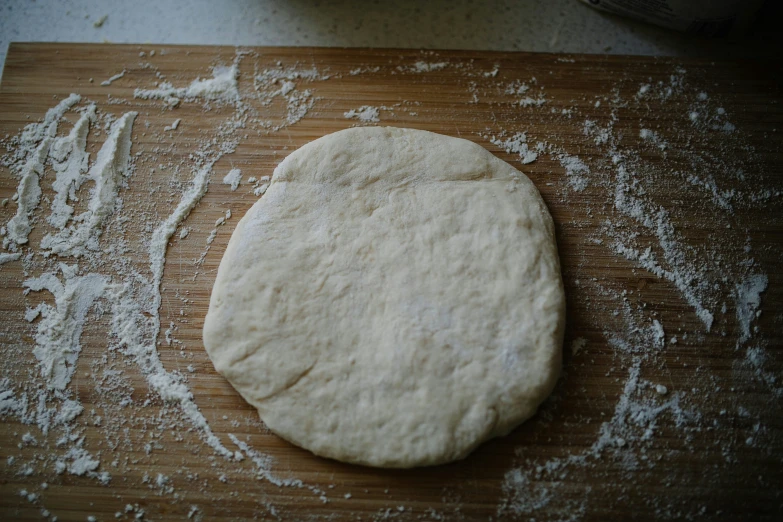 a wooden  board topped with dough