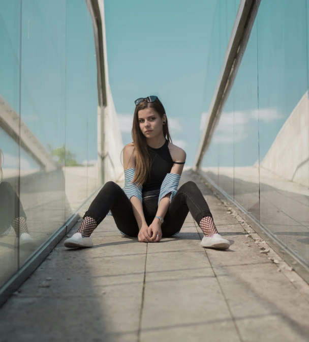 young woman sitting on stone walkway with shoes on