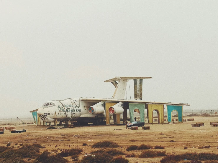 a building in the middle of the desert with people on it