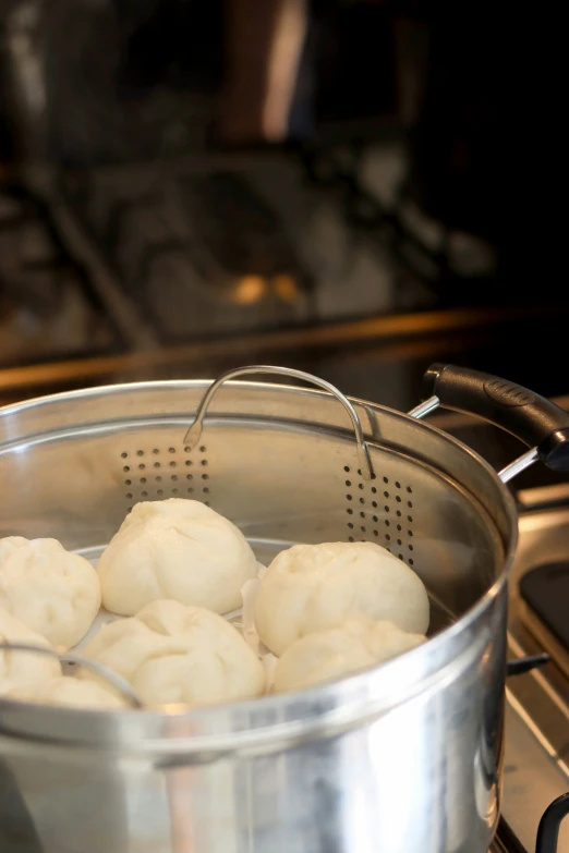 some dumplings in a pot next to a stove