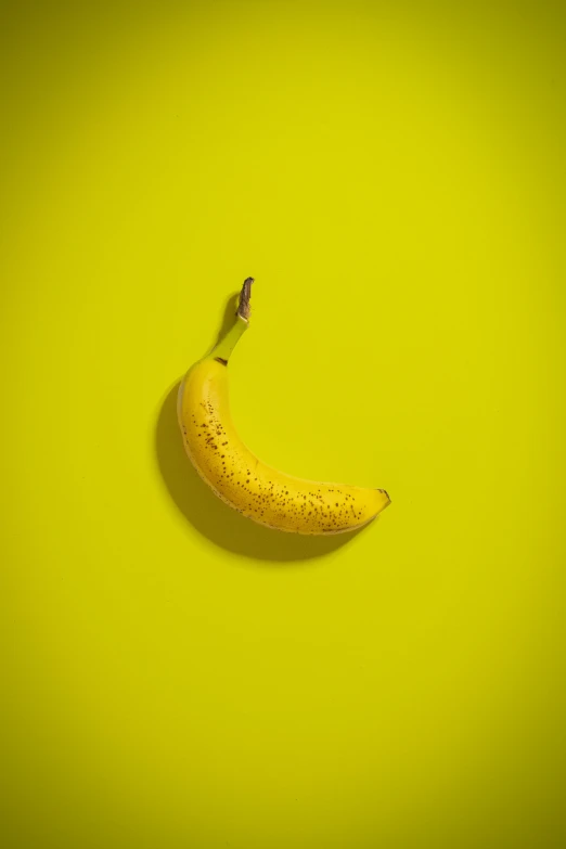 an apple and banana with a single ripe banana on a green background