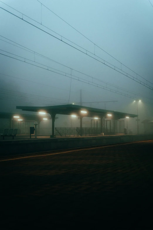 an empty bus stop with power lines and a train