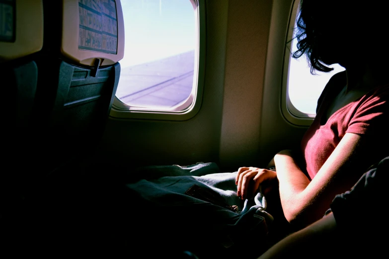 a woman looking out an airplane window on a flight