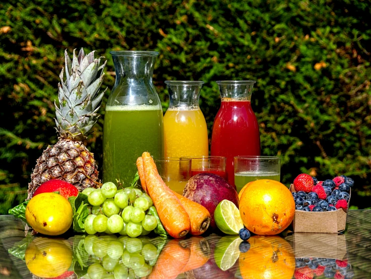 various beverages are in glasses next to bottles