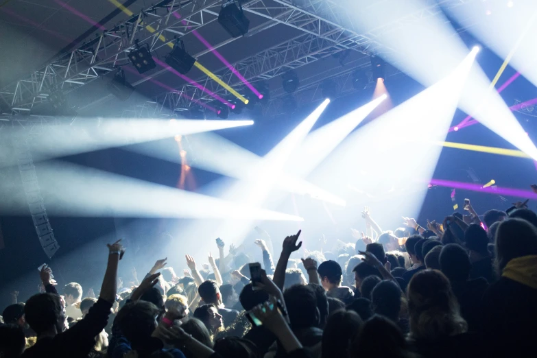 an audience at a music concert with the lighting on