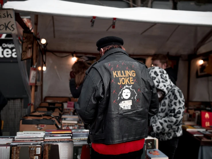 the man wearing a black jacket has a black leather jacket with a skull on it