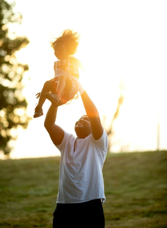 a man holding a small child up to the sky