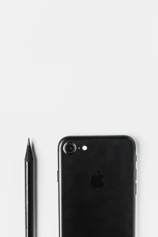 an iphone and pen are lying on the table