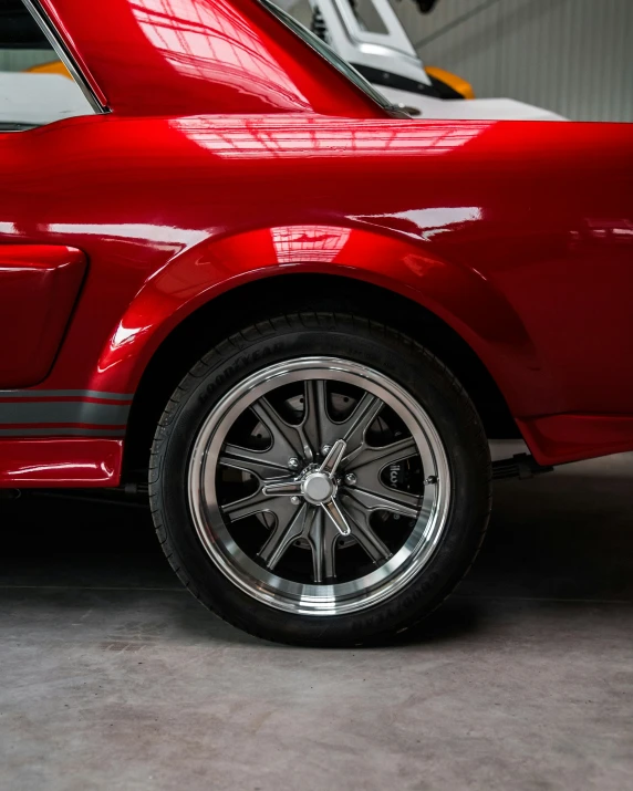 red sports car with new wheels parked in a garage