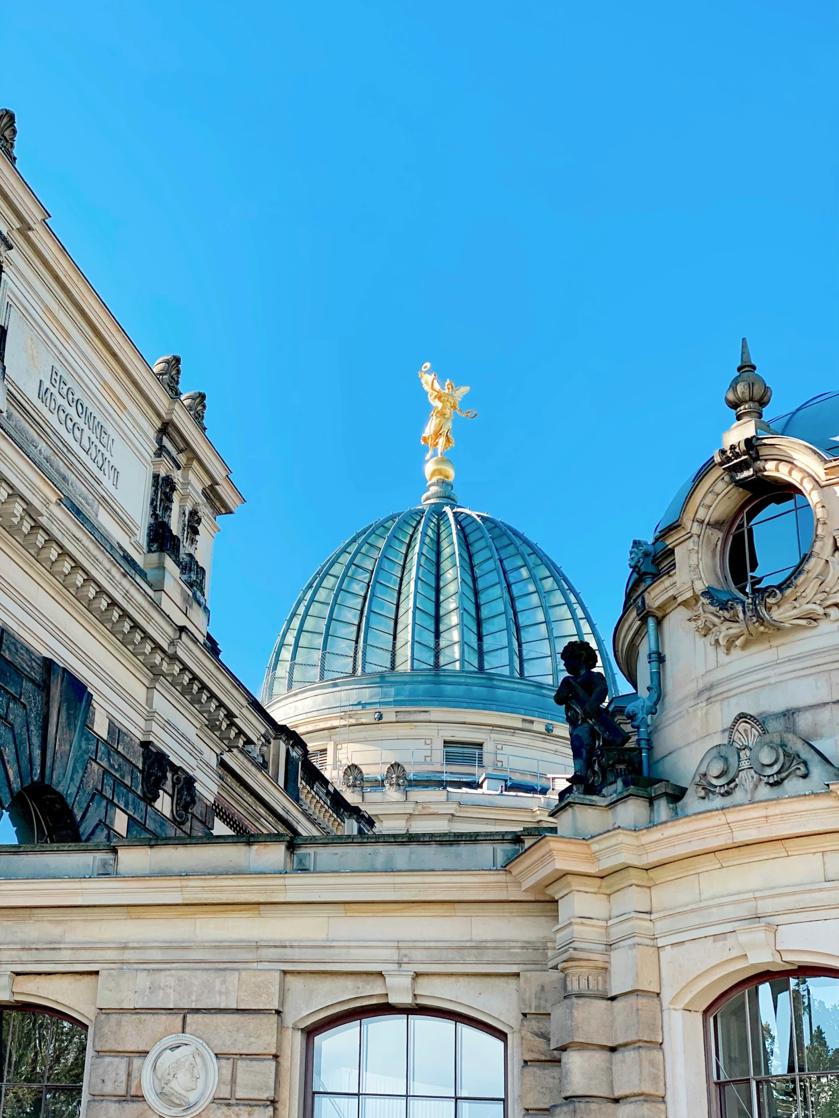 a blue domed building with sculptures on top