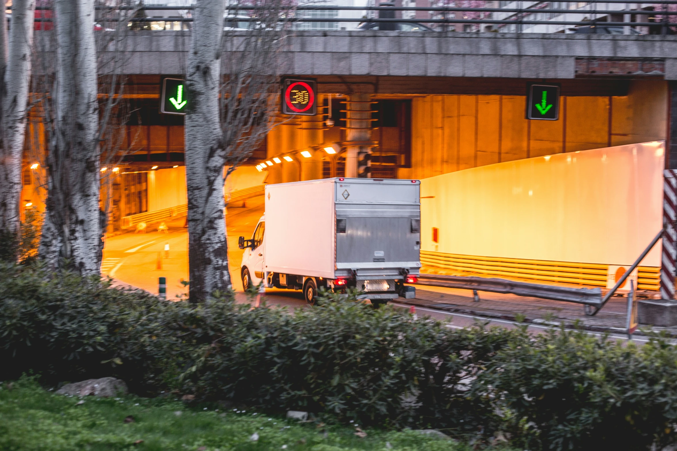 the back side of a semi truck that is sitting in front of a road