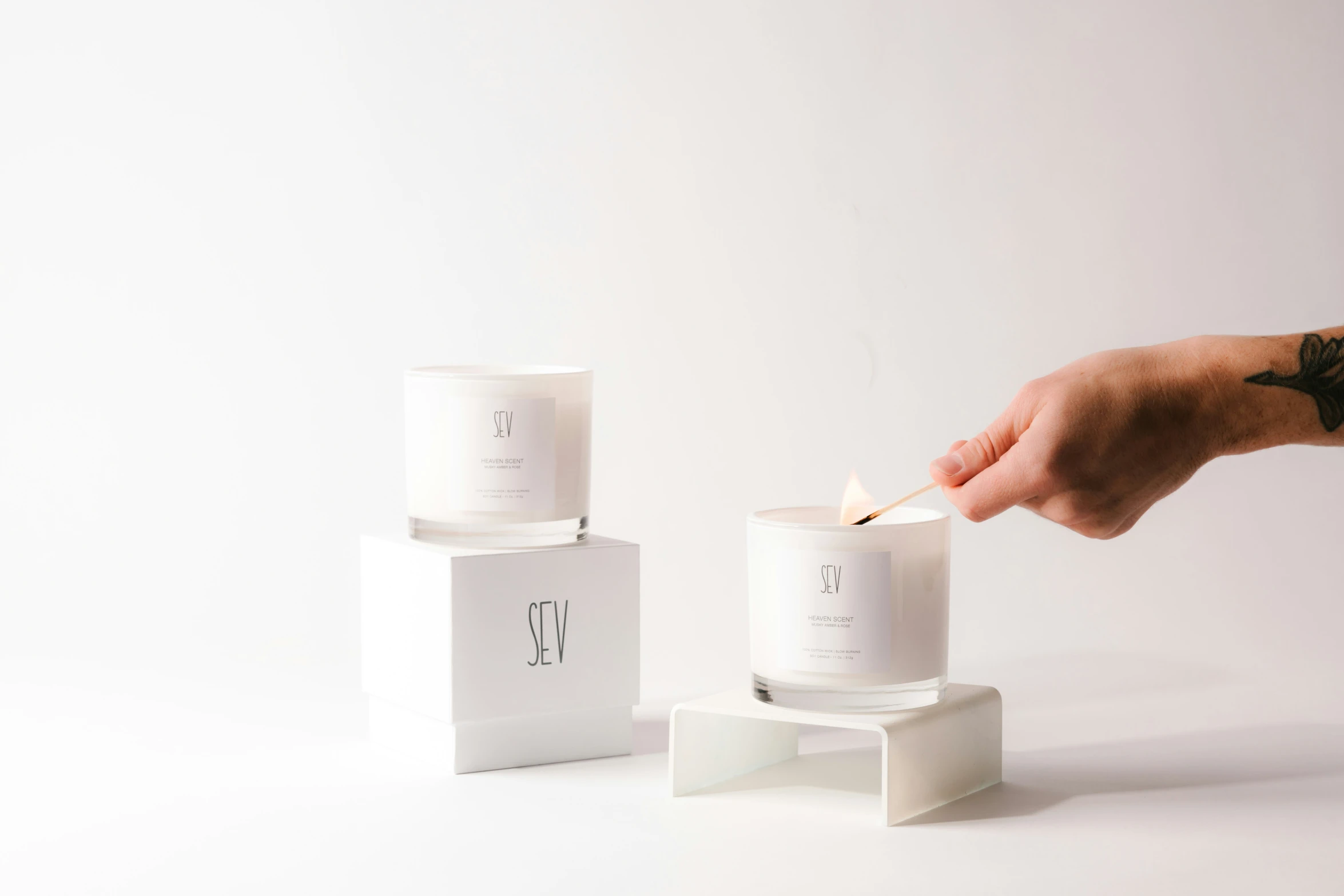 a person lighting candles in a small white box