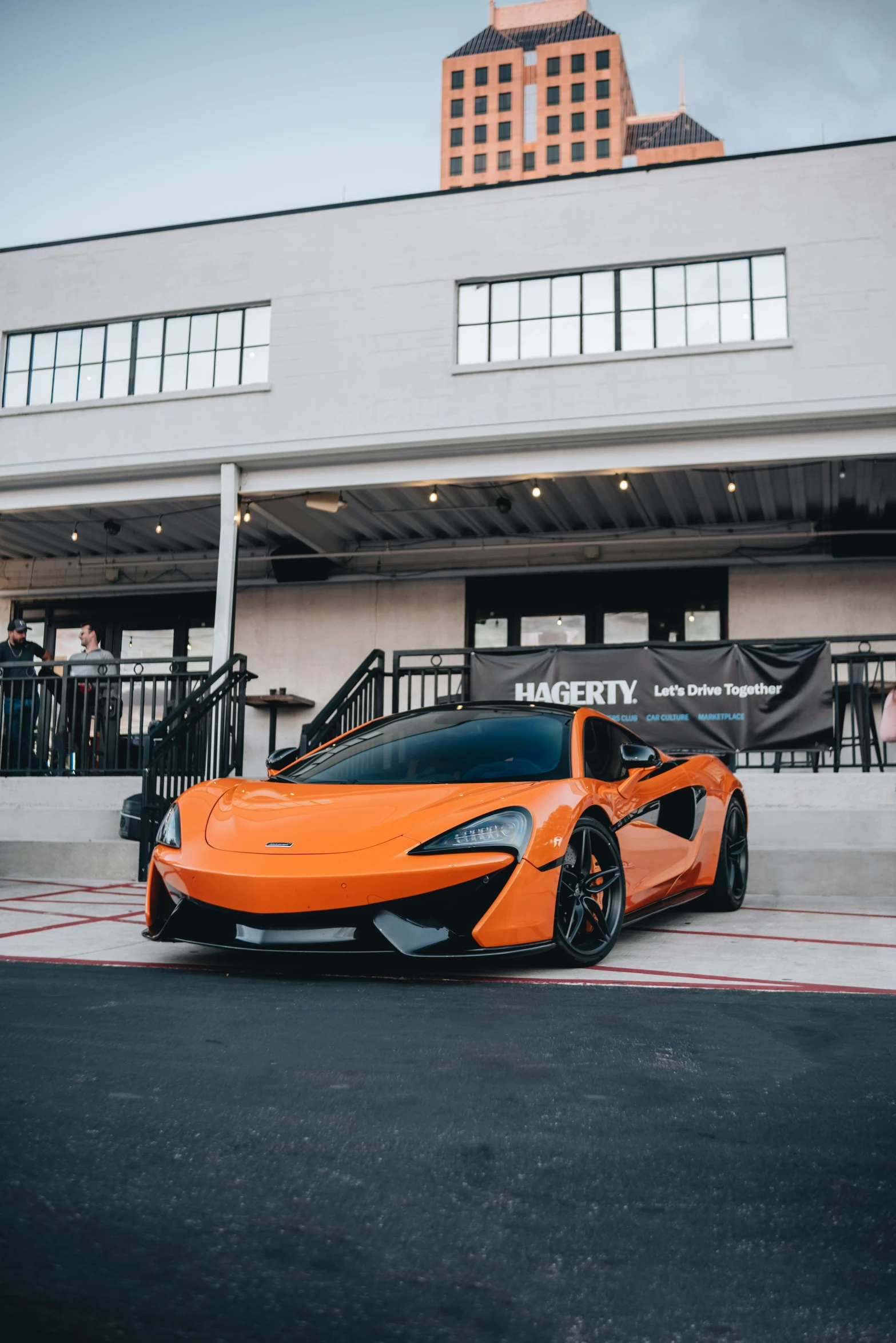 an orange sports car is parked in front of a luxury el