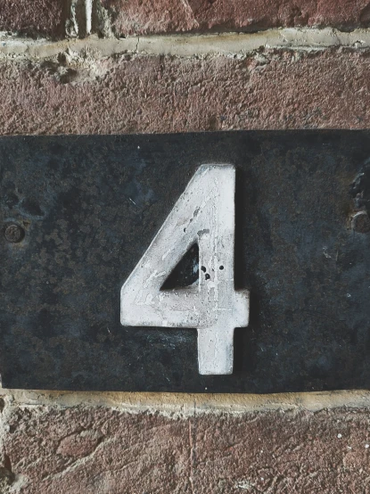 an older metal sign with the number four