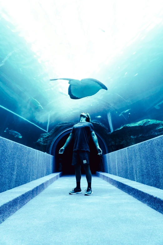 the man is standing on the edge of a tunnel under the ocean