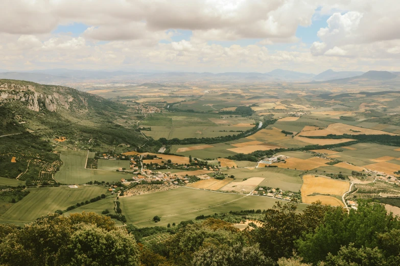 green valley with fields and hills with clouds