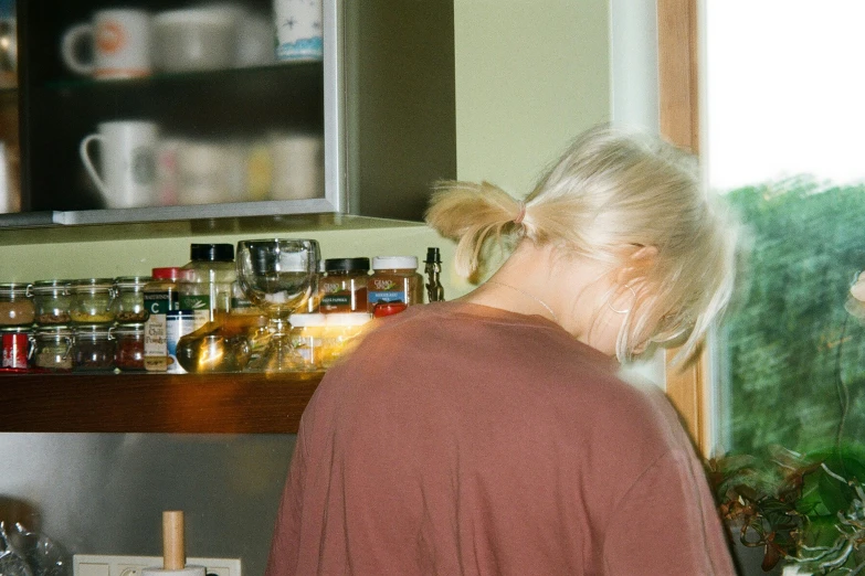 two women standing in a kitchen preparing food on a wooden counter