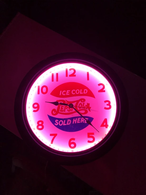 the neon clock has an interesting red face and is lit up