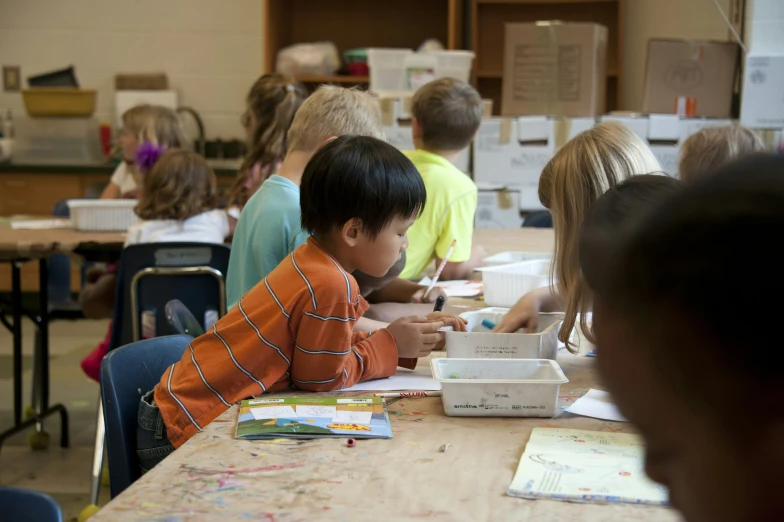 there is a boy writing on the desk at the table