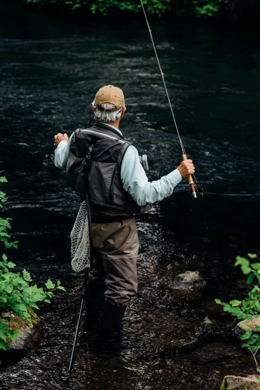 a man fishing in the water with a fish pole