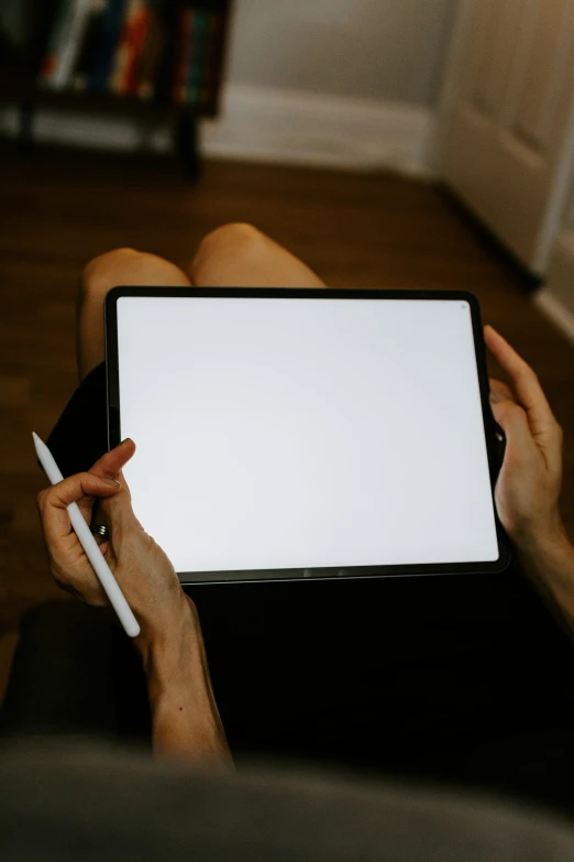 someone holding up a whiteboard and pen in their hands