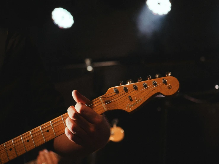 a man playing an electric guitar in a dark room