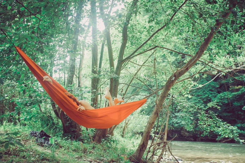 a young woman with a towel lying in a hammock